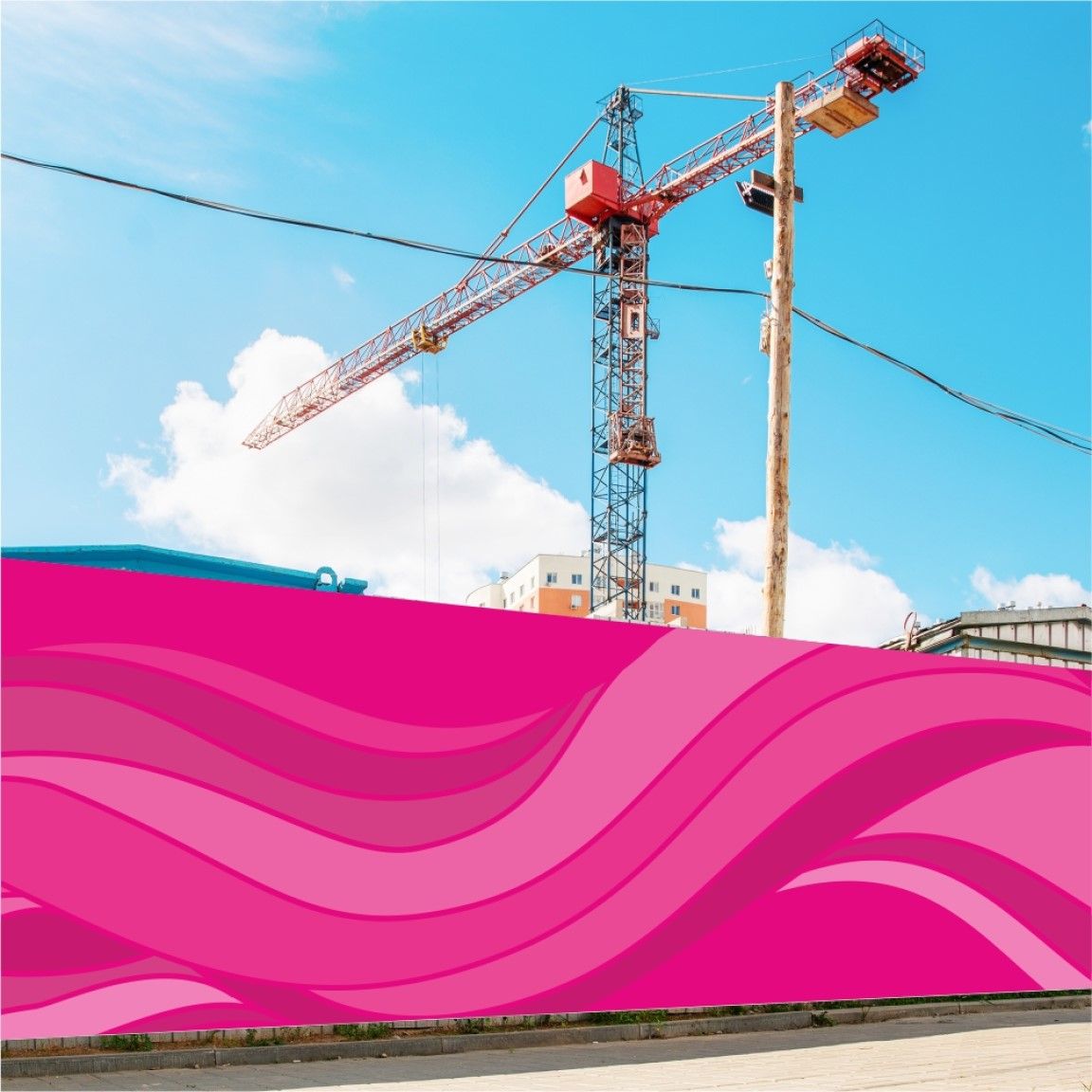 A printed hoarding board installed along a construction site boundary, displaying large-format graphics while a crane is visible in the background. 